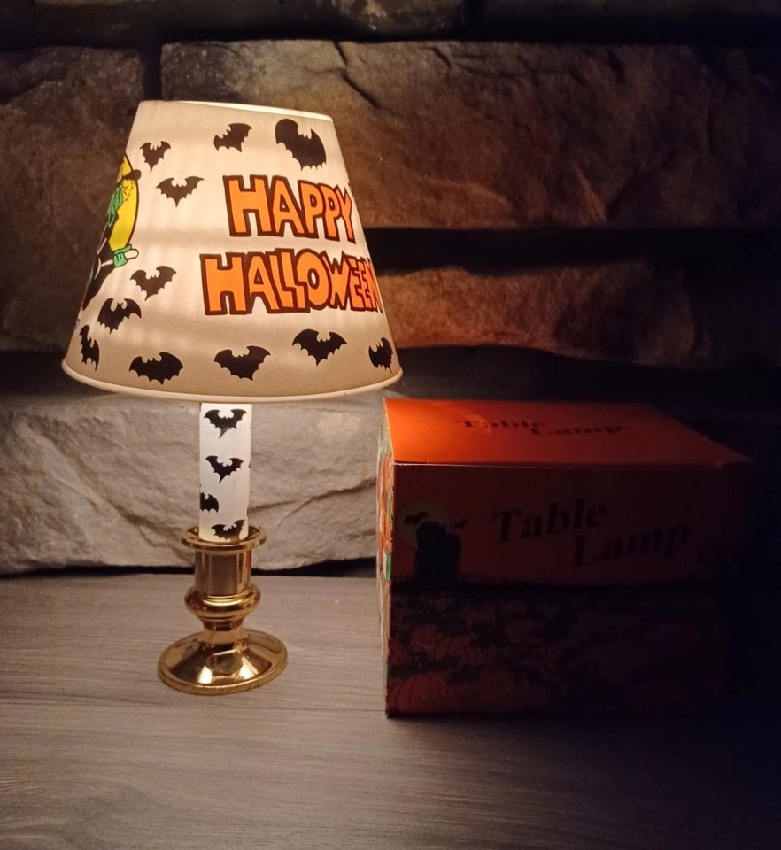 A vintage Halloween table lamp with a witch-and-bats design — functional spooky decor that doubles as a collectible art piece.