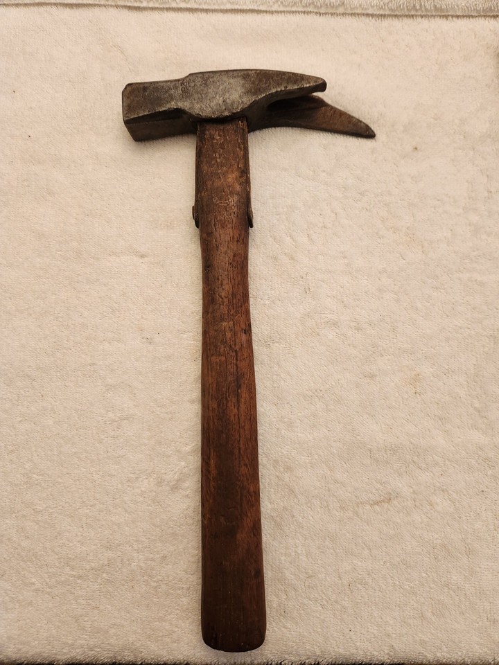 An antique claw hammer with a wrapped strap handle instead of a wood or fiberglass grip — a genuinely unusual construction that makes it a conversation piece and collectible.