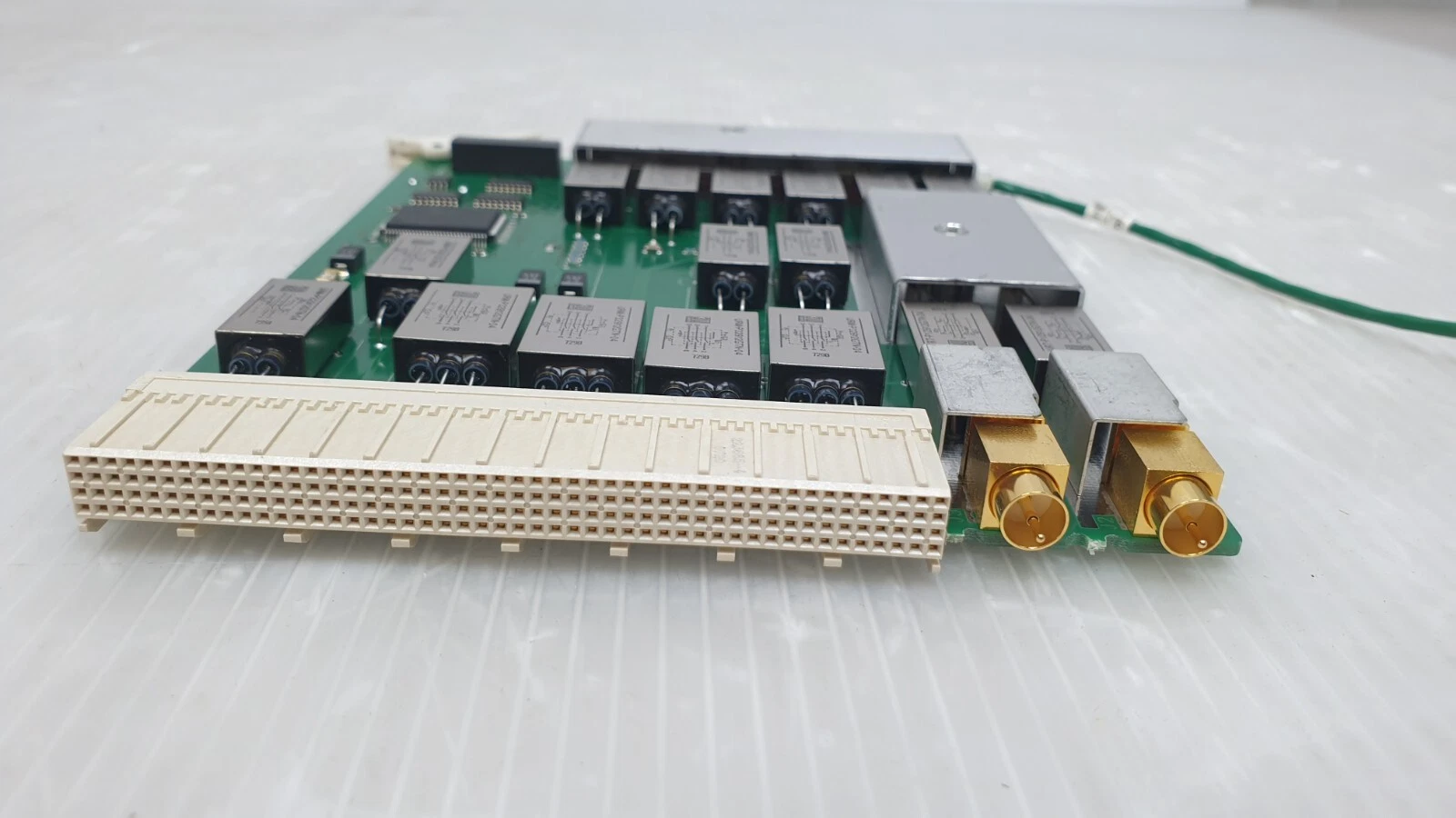 Edge view of the E3121-66511 multi-row backplane connector and two gold coax jacks
