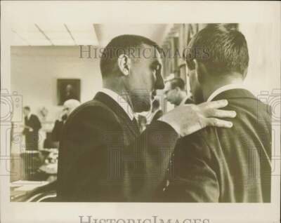 1961 Press Photo A man puts his hand on another man's shoulder as they talk