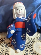 A Hakata Traditional Clay Figurine From Japan.Dressed In A Blue And Red Kimono.