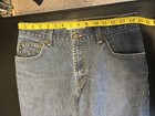 AX Armani Exchange J40 women’s blue short regular bootleg jeans with five pockets, yellow measuring tape across the waistband.