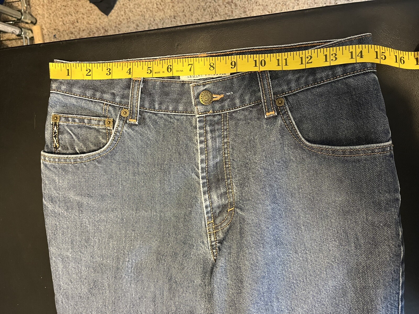 AX Armani Exchange J40 women’s blue short regular bootleg jeans with five pockets, yellow measuring tape across the waistband.