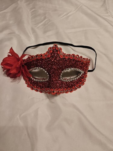 red masquerade mask Mardi Gras edged with ribbon flower on side