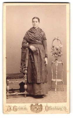 Fotografie J. Grimm, Offenburg, Frau mit Schal neben Stuhl und Blumenständer 