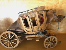 Vintage-style wooden stagecoach model with leather accents and metal details.