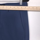 Blue 32 slim-fit THEORY men’s dress pants with front button closure, belt loops, and straight hem, hanging on wooden ruler.