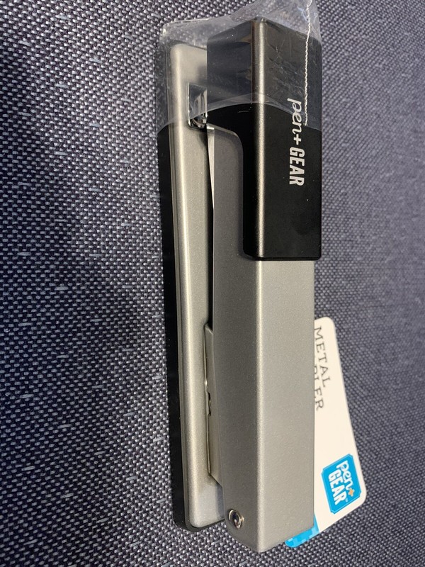 office trio stapler, hand held calculator and red ink pens