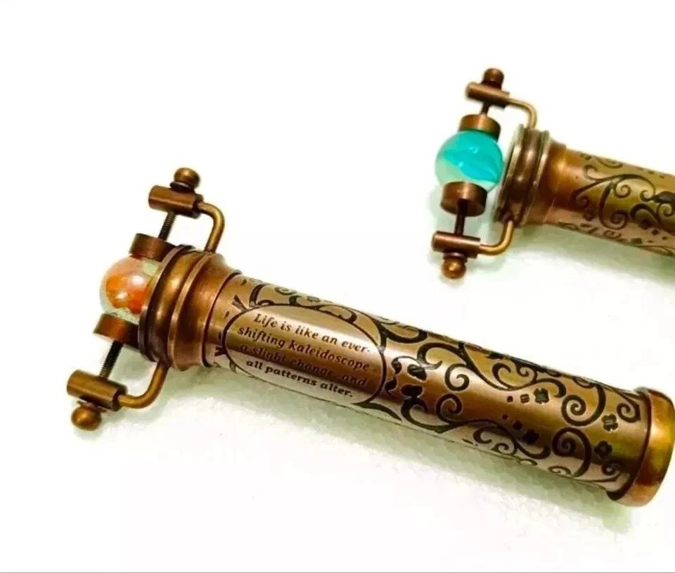 A solid brass kaleidoscope with a glass marble end — functional vintage-style optical toy that looks great on a shelf or in hand.