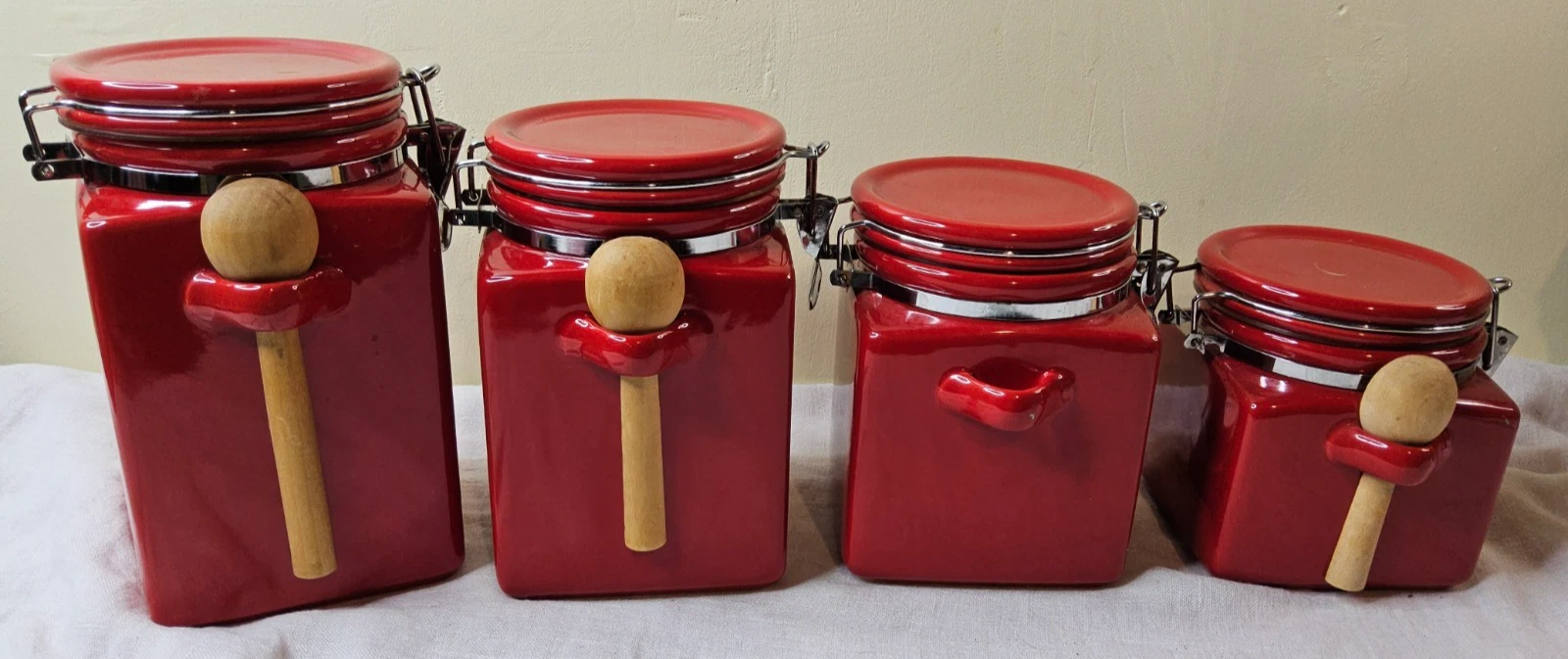 set of 4 Red Ceramic Canisters with secure locks and 3 wooden spoons