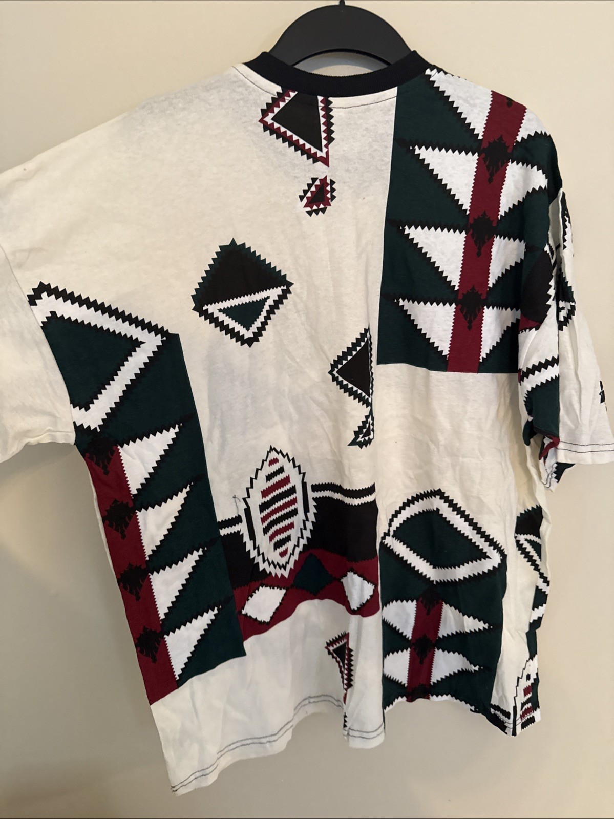 White vintage T-shirt with black, green, red, and black diamond geometric pattern and red “Made in U.S.A.” text.