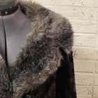 Brown fur-lined winter coat with soft textured fabric and pointed collar displayed on a mannequin against a white wall.