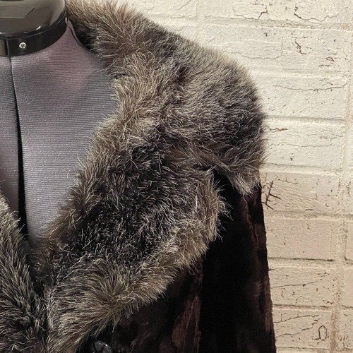 Brown fur-lined winter coat with soft textured fabric and pointed collar displayed on a mannequin against a white wall.