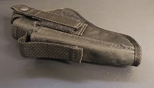 Black nylon IWB holster with textured grip, double stitching, and visible magazine holder on a gray surface.