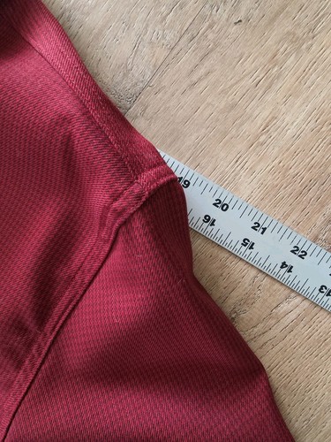 Red Filson virgin wool guide shirt with textured knit, measuring 2 inches along the seam on a light wood floor.