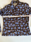 Brown and blue County Seat ladies shirt size M with floral print, laid flat with measuring tape along neckline.