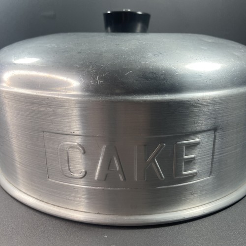 vintage 1950s aluminum cake topper that says in embossed letters “CAKE”