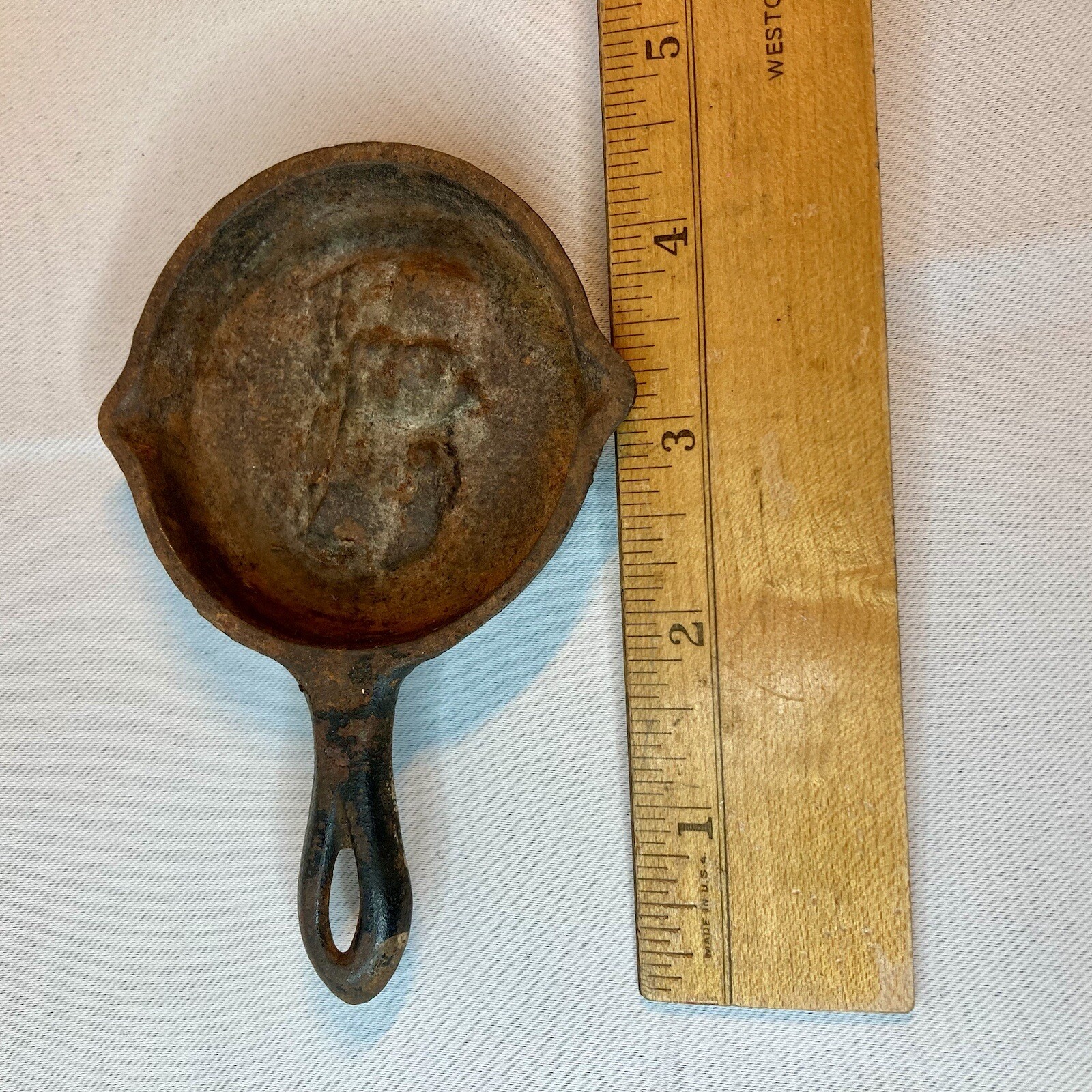 Small miniature cast iron skillet used as a novelty ashtray or spoon rest