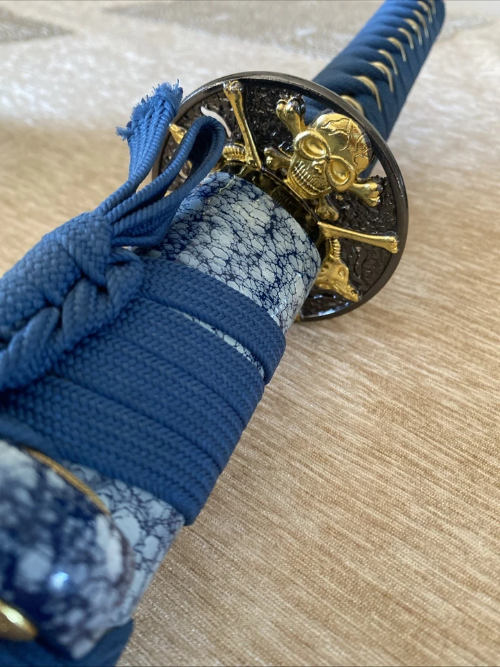 Una katana azul con una cara de monstruo impresa en ella extremadamente nítida y hermosa Foto 4 de 4