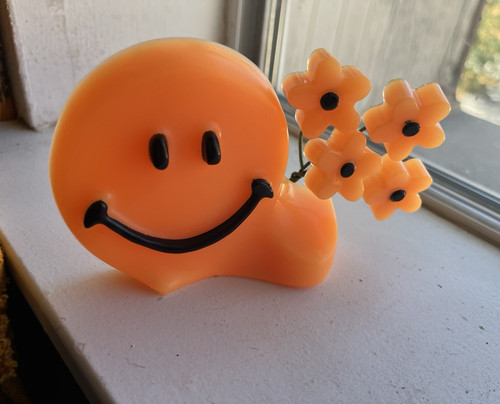 Orange and black smiley face with flowers