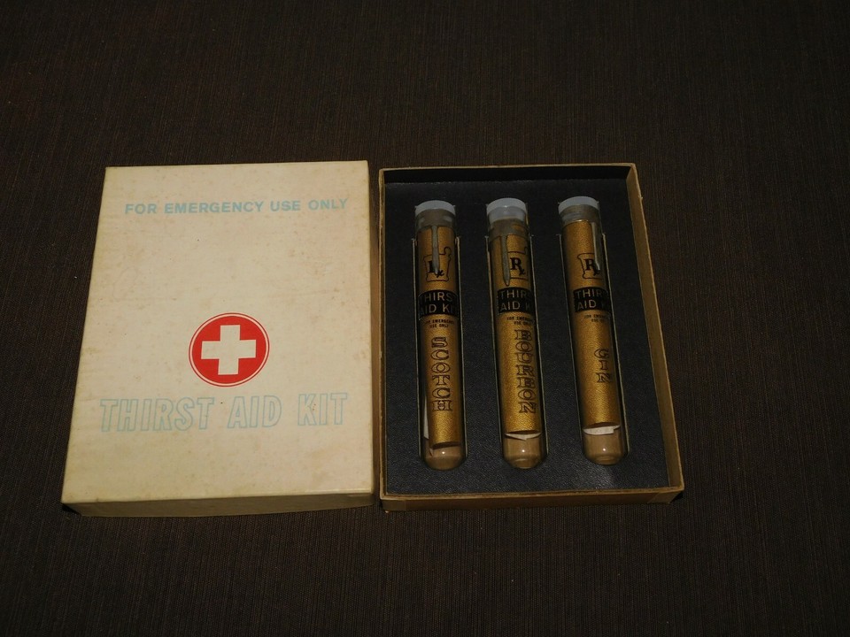 A vintage bar kit dressed up as an 'emergency first aid' box — a clever, visually striking piece of retro barware humor that doubles as a conversation-starting display item.