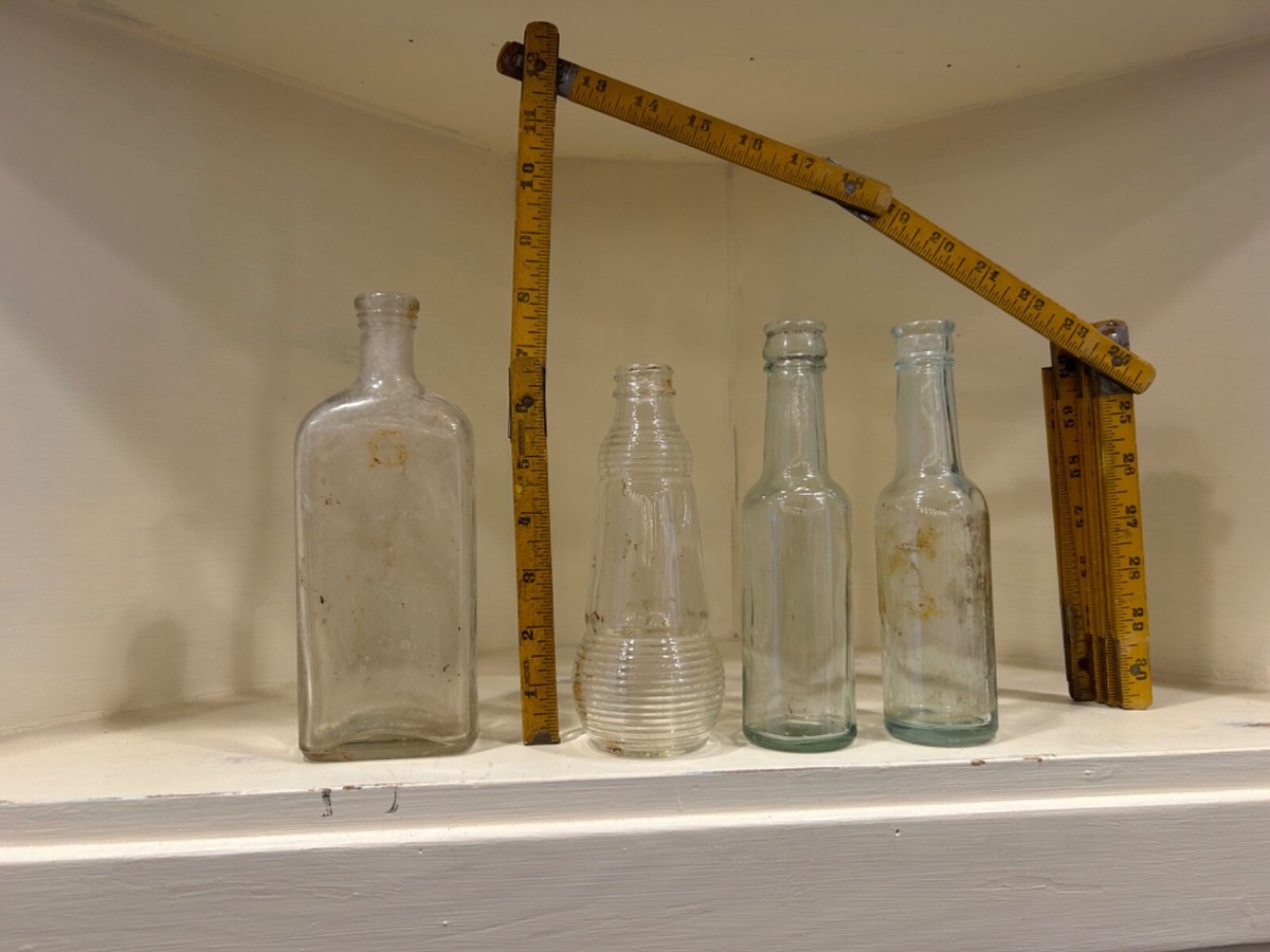 set of 4 vintage clear glass bottles one says O cedar on the