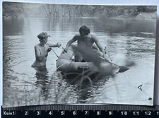 Young Shirtless Man In A Boat And A Woman In A Swimsuit On The Beach Old Photo
