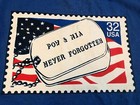 Blue EUC vintage 1995 T-shirt with U.S. flag design and text “POW & MIA Never Forgotten” on white dog tag.