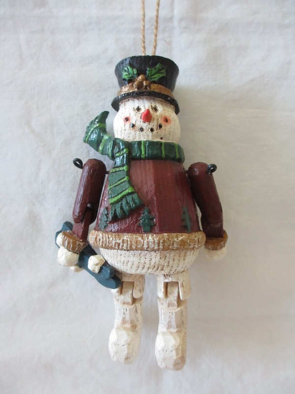 5.5 in Polyresin Snowman looks like wood. Arms and Legs Move. He is Holding Skis