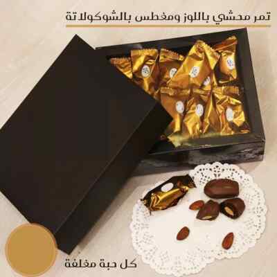 Dates stuffed with almonds and dipped in chocolate, each piece wrapped in a box