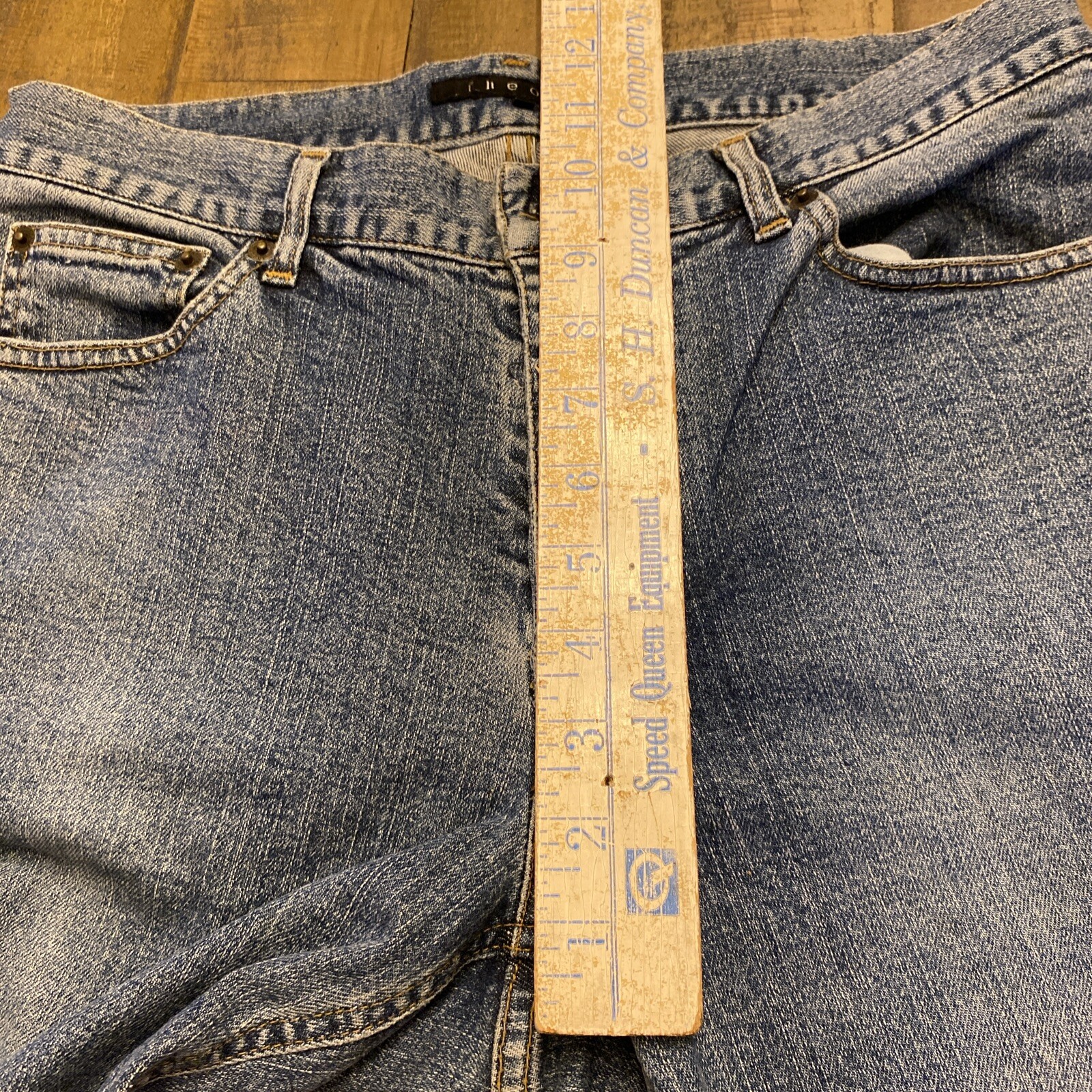 Blue denim Theory jeans, 30x33, with button fly closure, front pockets, and subtle faded detailing along the left leg.