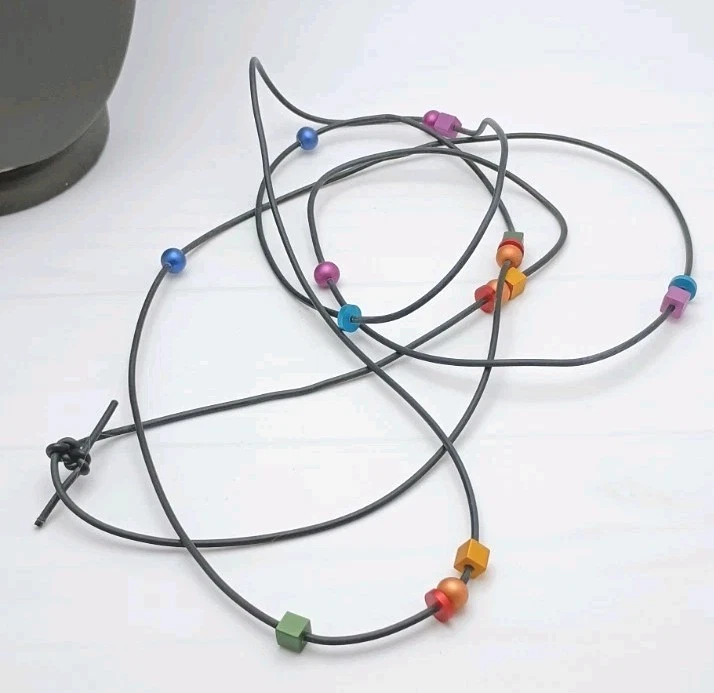 Collar de aluminio multicolor. Cuentas geométricas sobre cordón de goma negro. 70" Foto 4 de 4