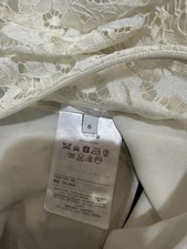 Italian-made luxury dress featuring, cream lace overlay bodice and black skirt.