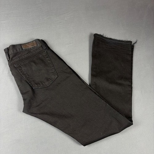 Black faded bootcut jeans with back pocket and brown leather patch on waistband, folded on light gray surface.