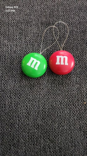 2 Stück Vintage M&M Topper Ornamente einer grün und einer rot.