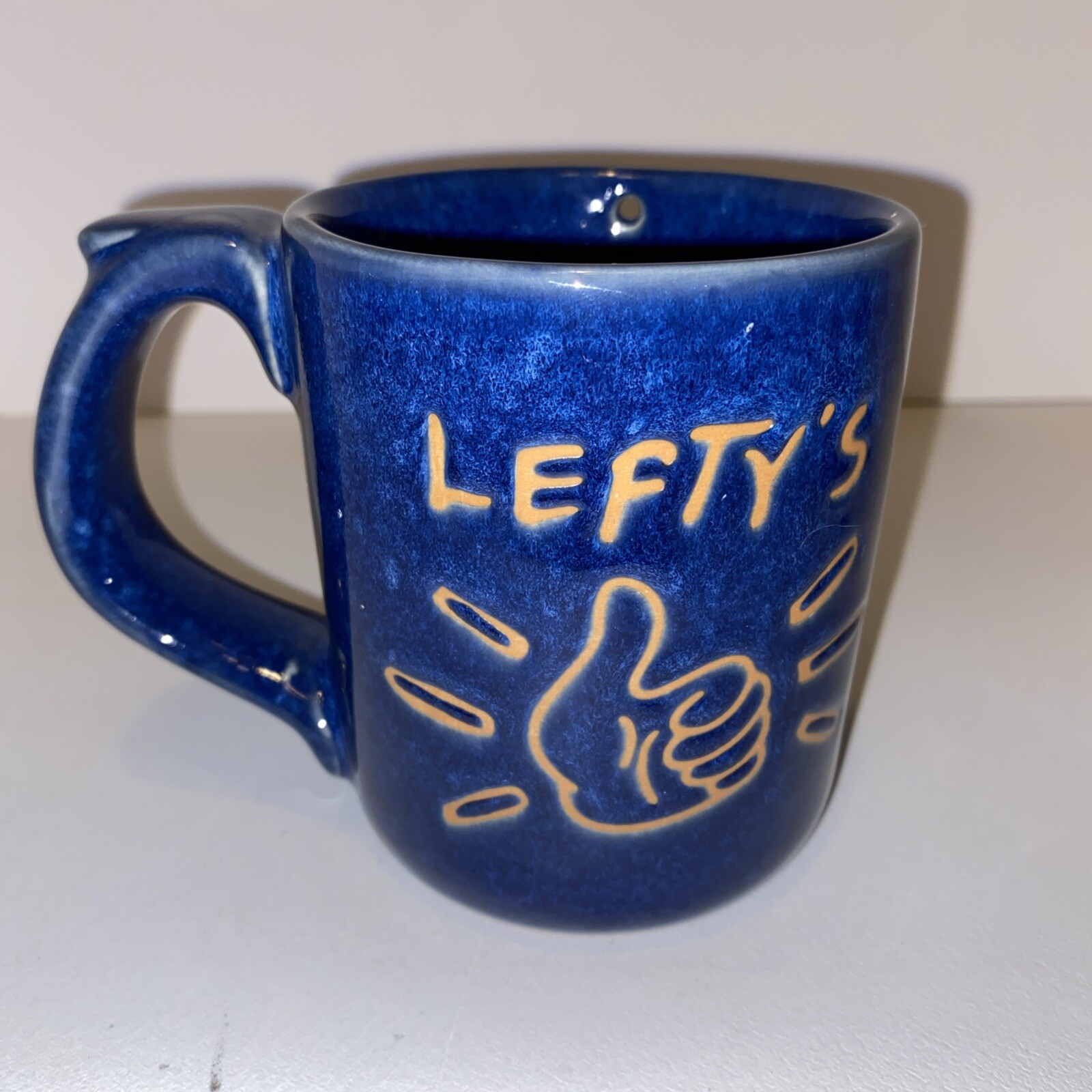 Lefty’s Left Handed Pottery Coffee Mug Cup Novelty Prank Hole Blue Drip Glaze