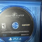 Blue PS4 Monster Hunter: World disc with Capcom logo, tested not for resale, in clear plastic case.