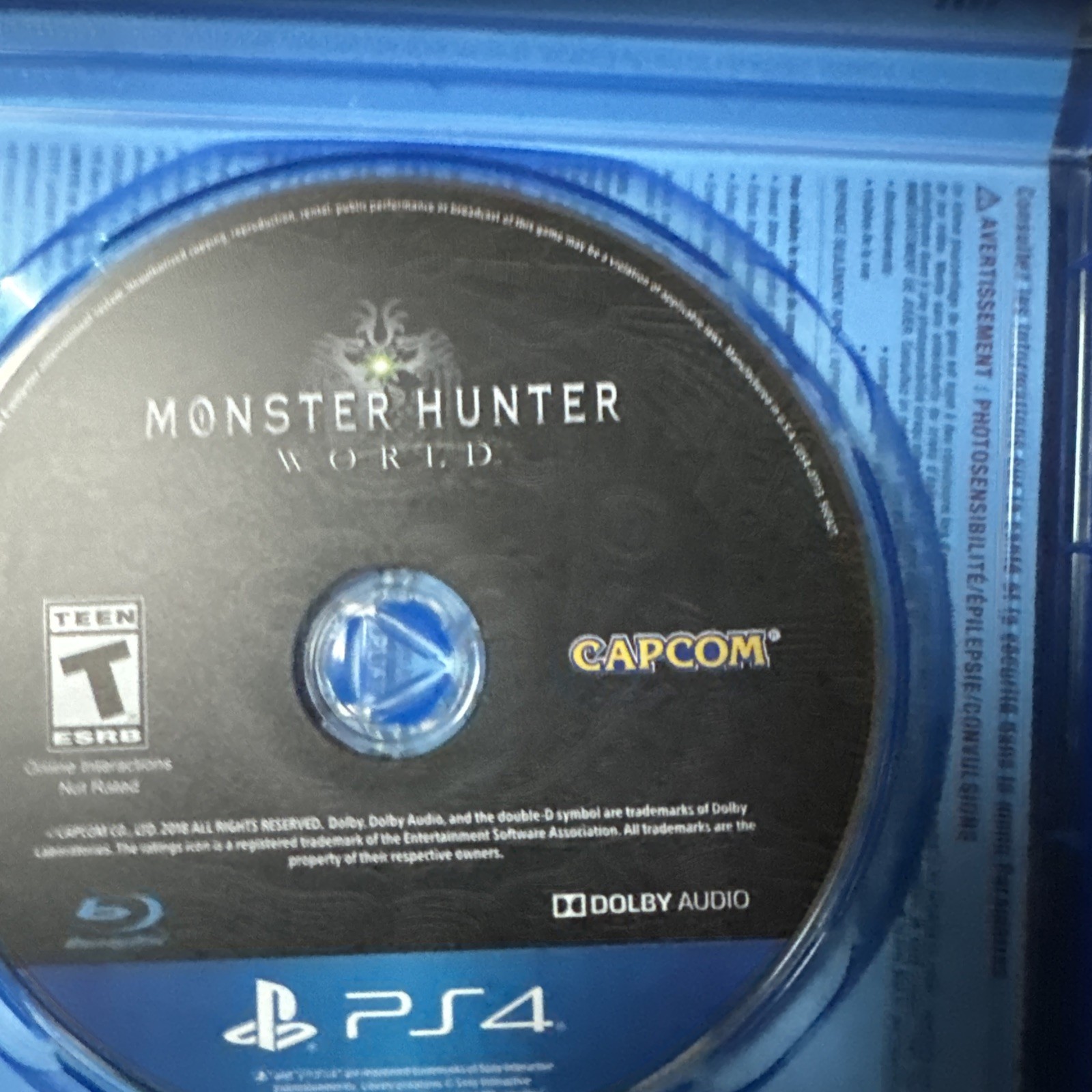 Blue PS4 Monster Hunter: World disc with Capcom logo, tested not for resale, in clear plastic case.