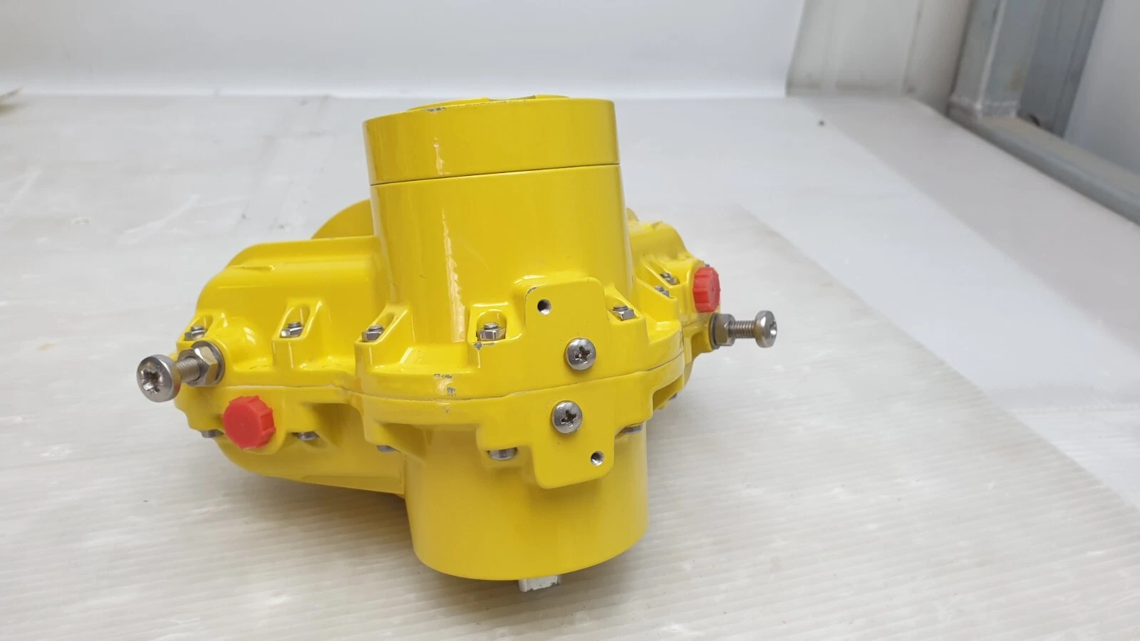 Side view of the Kinetrol 09 actuator with red air port plugs and end stop screws