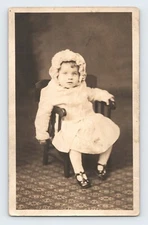 Toddler Child in Knitted Bonnet on Wooden Chair RPPC
