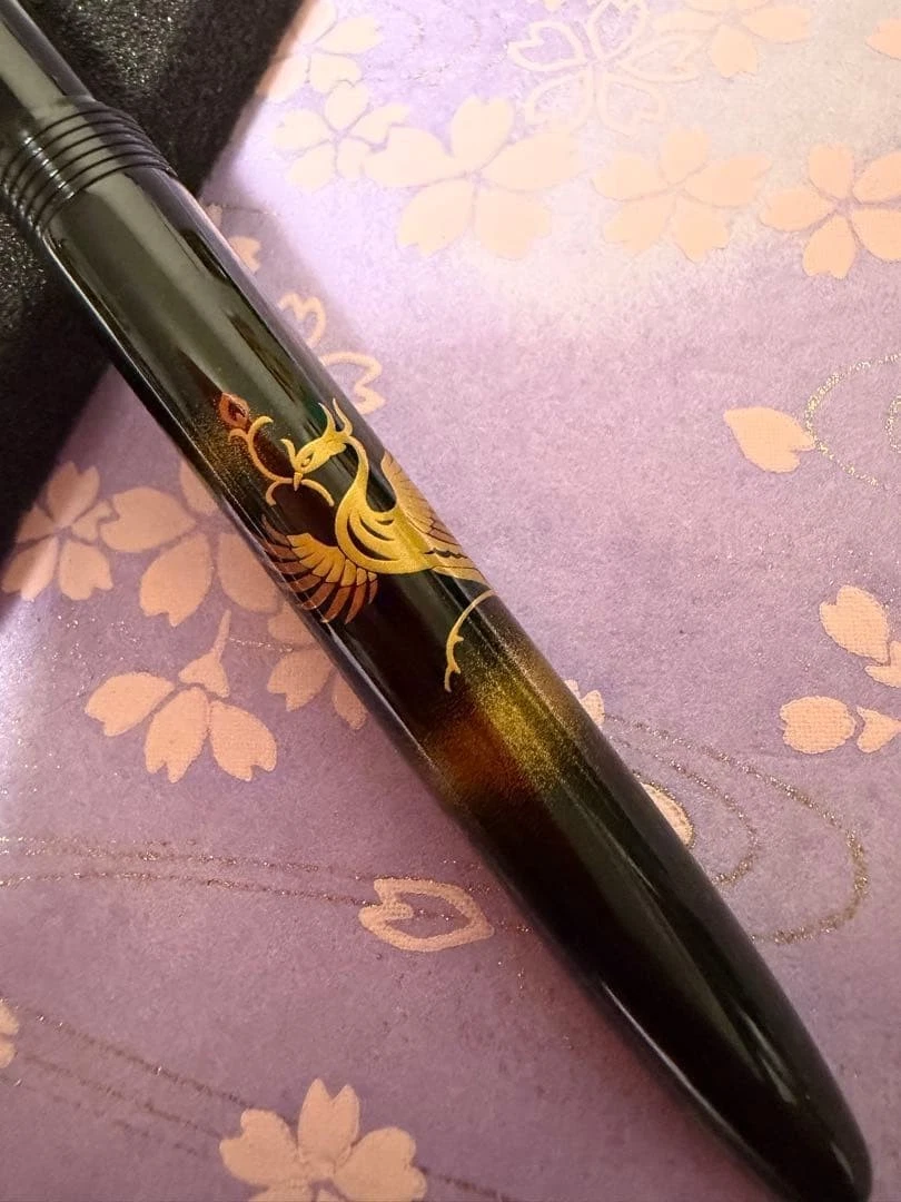 Brown UNUSED pilot fountain pen with gold ink, floral phoenix design, and “Maki-e Art Kokkokai” text on body.