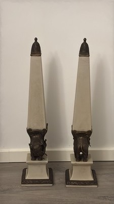 PAAR PORZELLANOBELISKEN MIT ELEFANTENMOTIVEN AUS MESSING, INSPIRIERT VON BERNINI