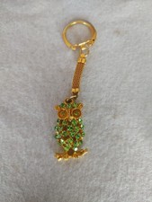 Gold-tone rhinestone owl keychain features a sparkling green crystal body
