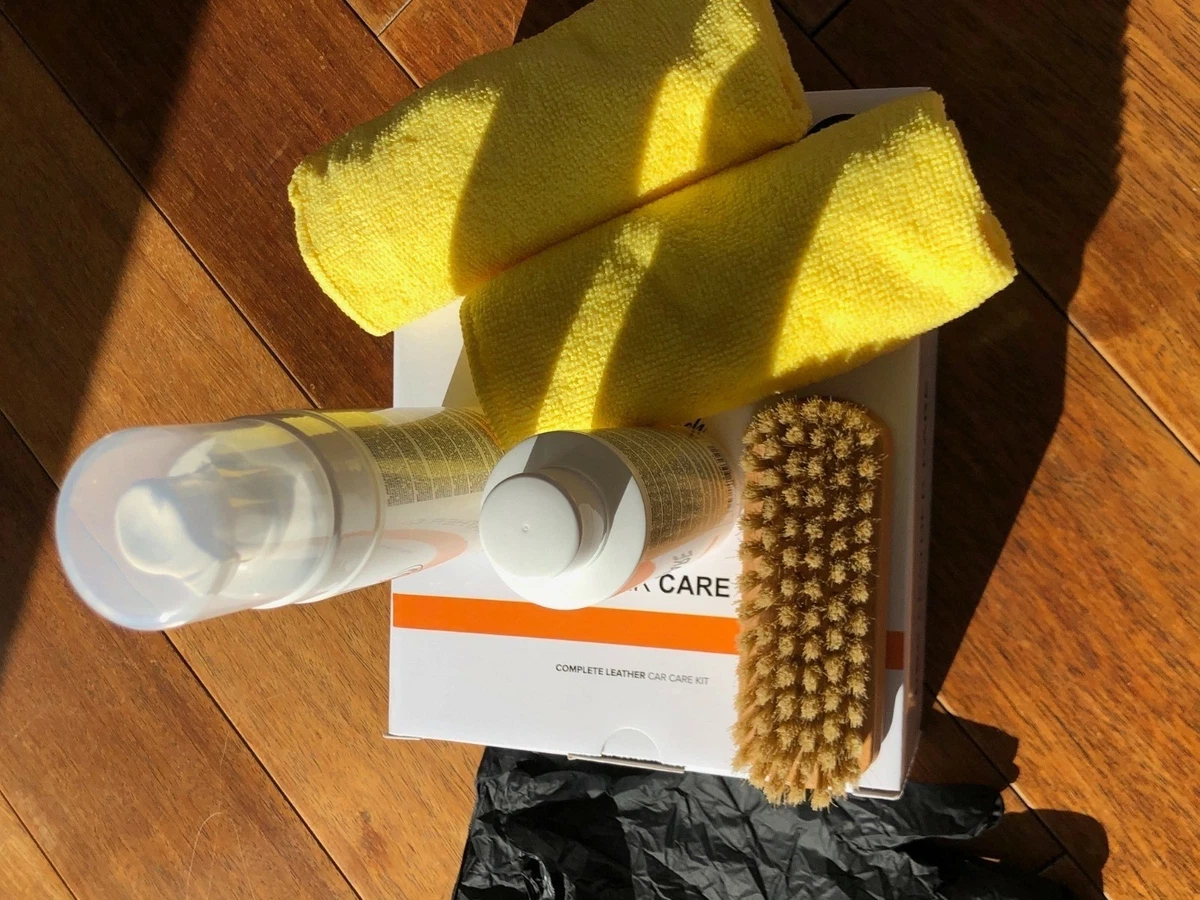 Microfiber towels, upholsery cleaning brush, upholsery cleaning product, upholsery protectant, and nitrile gloves, displayed on a wood plank floor.
