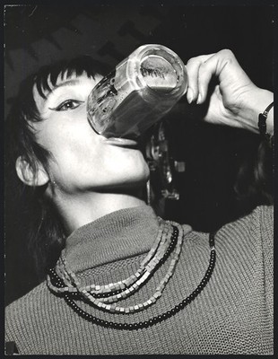 Photograph young woman taking a powerful train from a beer glass, party mood 