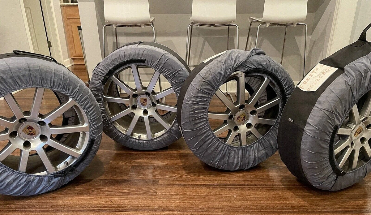 A set of four Porsche 911S wheels with Nokian winter tires with tire storage bags in a dining room.