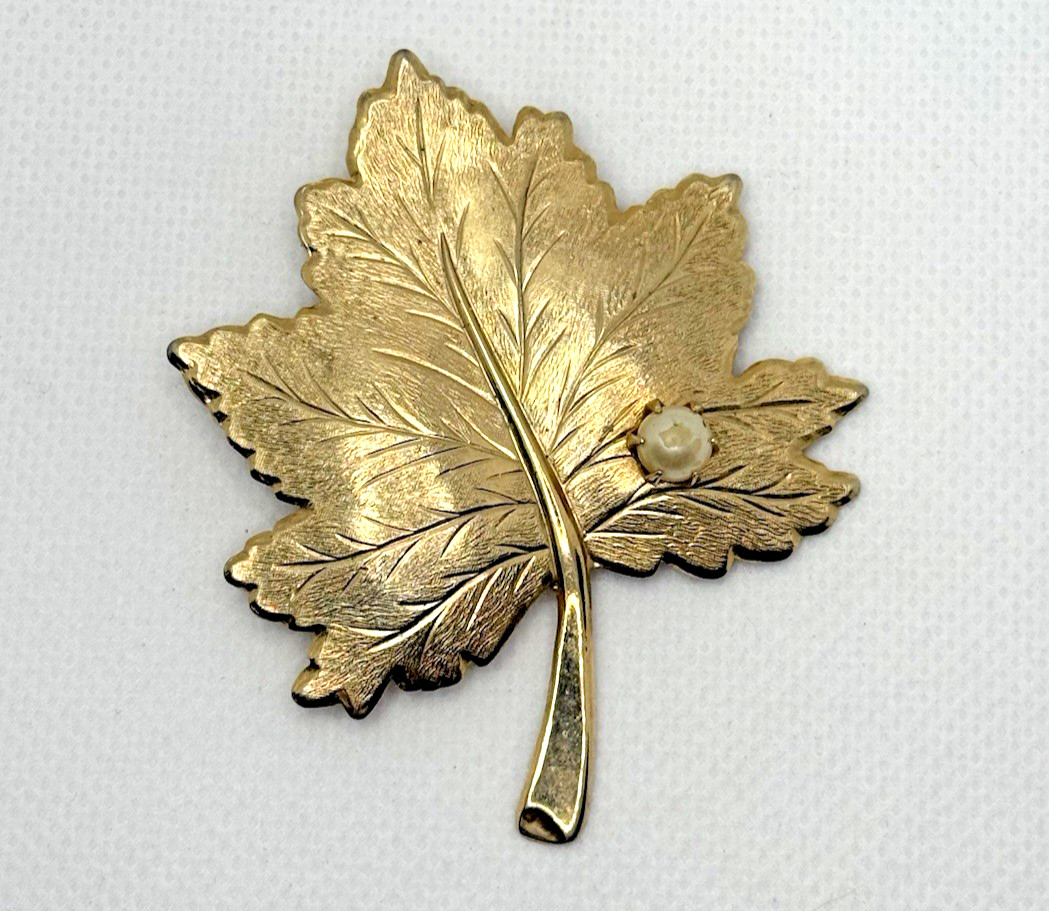 Gold tone Sarah Coventry maple leaf brooch with a faux pearl accent
