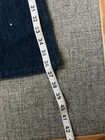 Dark wash 1990s Levi’s Superlow 518 bootcut jeans, waist 31, laid flat with measuring tape along the side.