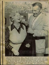 1975 Press Photo Buster Crabbe helps Mina Wylie with her jacket, Fort Lauderdale