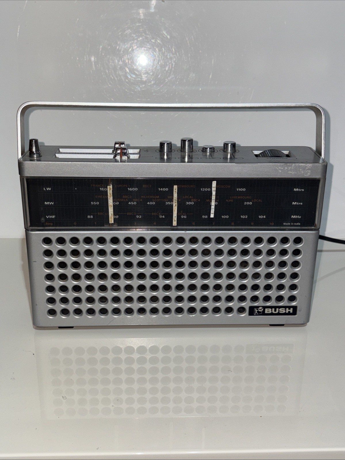 vintage Bush brand portable radio featuring a silver case and a carrying handle